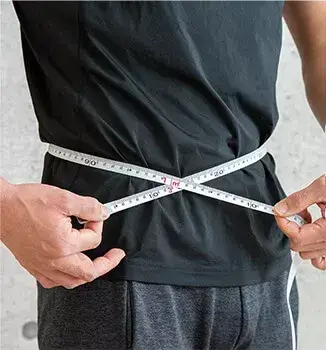 Mężczyzna mierzy obwód w pasie centymetrem; otyłość a wątroba, czy wiesz, jak nadwaga wpływa na zdrowie tego kluczowego organu?
