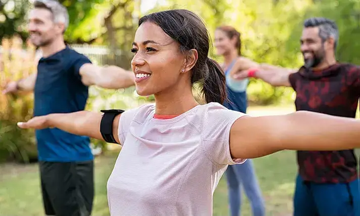 Grupa ludzi ćwiczy w parku; nie tylko dieta wspomaga oczyszczanie wątroby, również zdrowy styl życia dodaje energii.